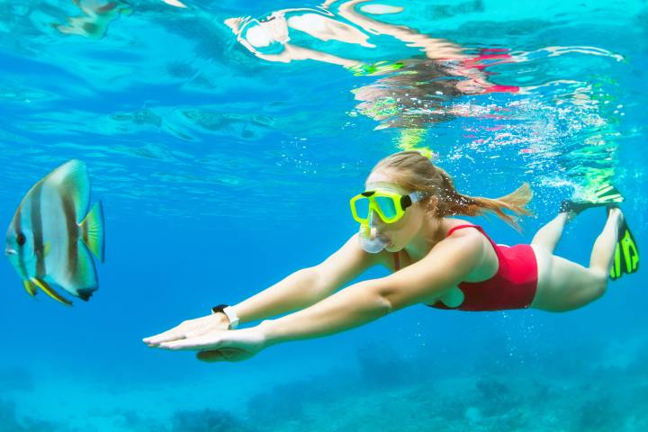 a woman swimming in the ocean at the coral reefs
