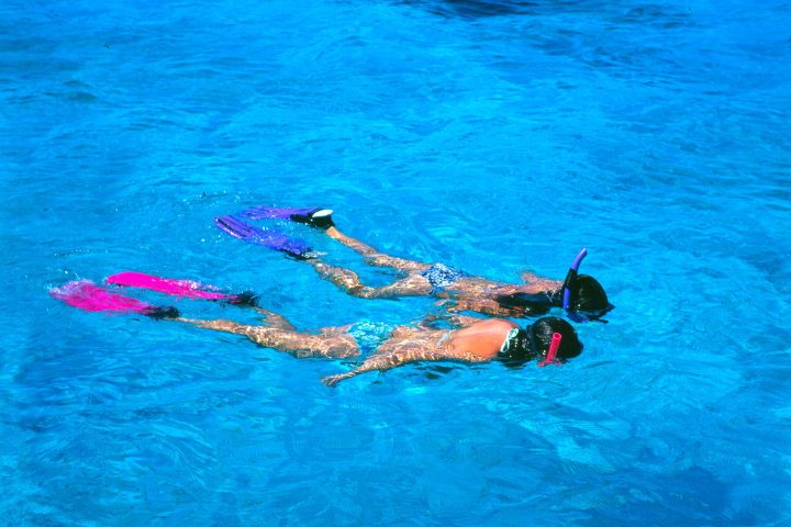 Couple snorkeling in blue water at Pennekamp coral reef in Key Largo