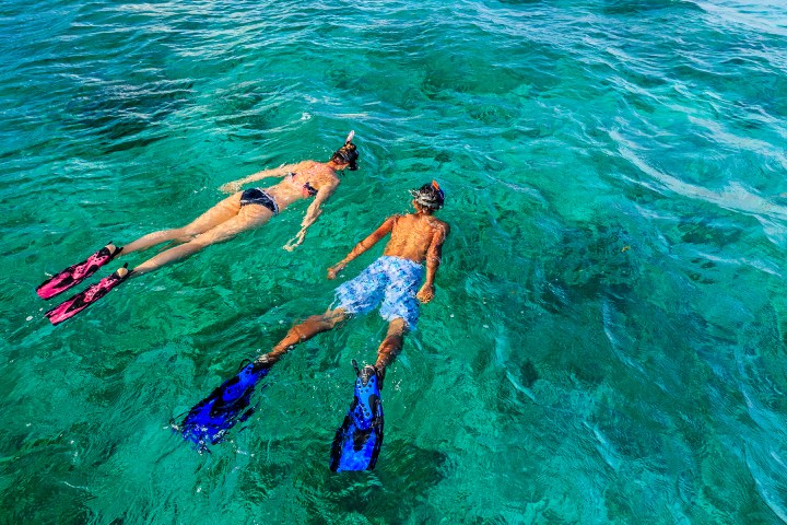 Young couple snorkeling at shallow coral reefs in Key Largo