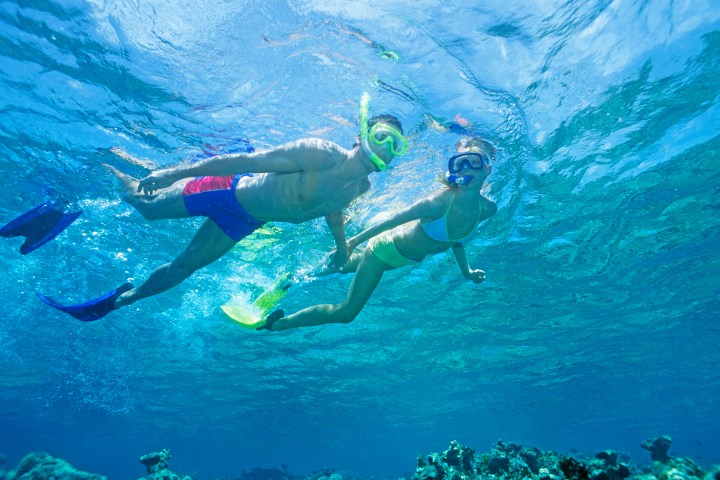 Young couple snorkeling above coral reef in Key Largo